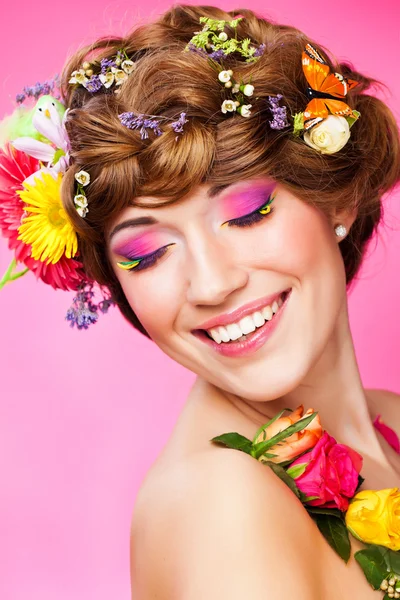Νεαρή γυναίκα με φωτεινά αίγλη μακιγιάζ και λουλούδια — Φωτογραφία Αρχείου