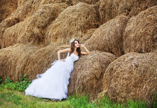 Mooie bruid in hooi stapel op haar trouwdag Stockfoto