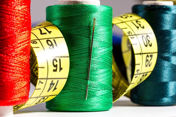 Spools of thread, needle, measuring tape, button — Stock Photo, Image