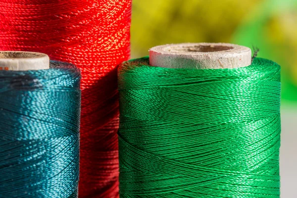 Macro green, red, blue spools of thread — Stock Photo, Image