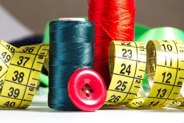 Spools of thread, needle, measuring tape, button — Stock Photo, Image