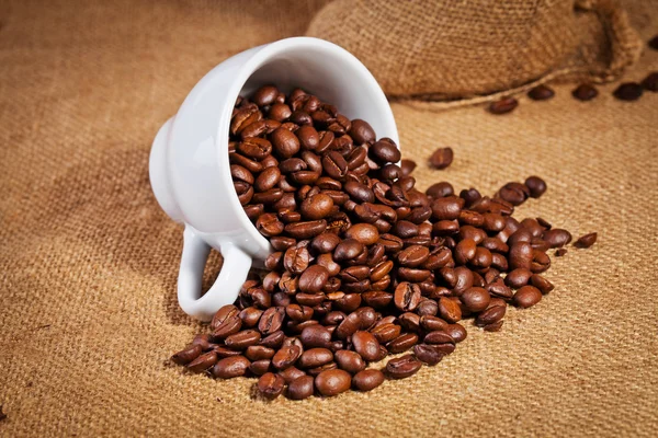 Xícara de café e feijão arábica no saco de pano — Fotografia de Stock