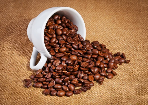 Kaffe kopp och arabica bönor på duk säck — Stockfoto