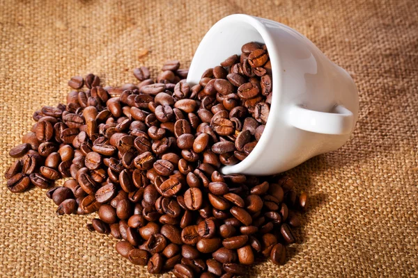 Kaffe kopp och arabica bönor på duk säck — Stockfoto