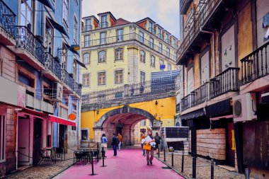 Pink street and arched bridge in Lisbon, Portugal. City landscape.