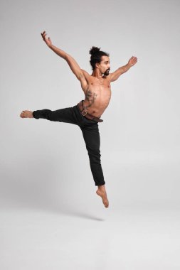 Handsome black guy dancing topless on a white background.