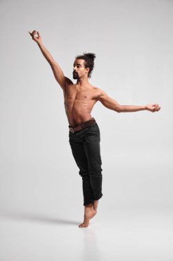 Gri arka planda dans eden yakışıklı, sportif siyah adam..