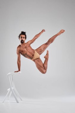Handsome black guy dancing topless on a white background.