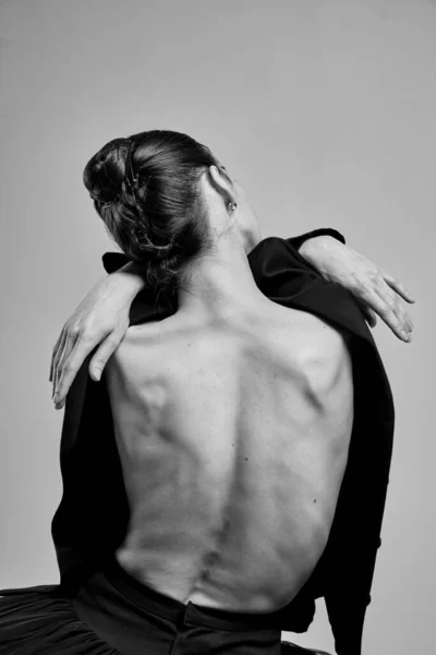 Girl with his back in a jacket posing in the studio.