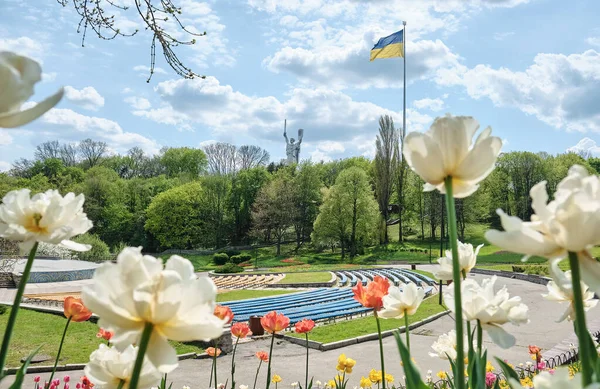 View from the spring park on The Motherland Monument and the main flag of Ukraine in Kyiv.