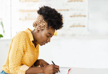 Güzel siyah kadın portresi. Not defteri yazıyor. İş kızı eğitimi alıyor.