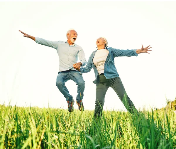 Женщина мужчина на открытом воздухе пожилая пара счастливый образ жизни выход на пенсию вместе любовь прыжки весело природа зрелая — стоковое фото