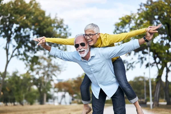 Пожилые пары любят вместе счастливые объятия дома семья пожилой мужчина женщина выход на пенсию улыбаясь piggyback — стоковое фото