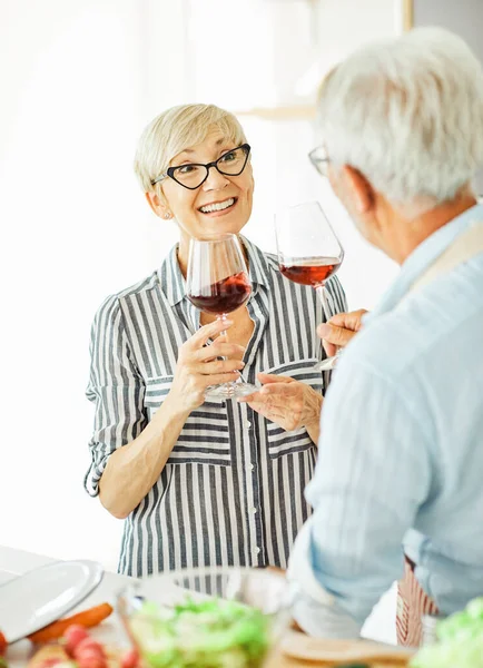 Любовь кухня старшая стеклянная женщина пара дома на пенсию счастливая еда улыбаясь муж вино вместе портрет — стоковое фото