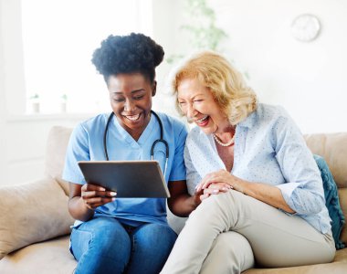 Hemşire doktor kıdemli bakıcı tablet teknolojisi emeklilik evi huzur evi yaşlı kadın sağlık desteği Afro-Amerikan siyahi