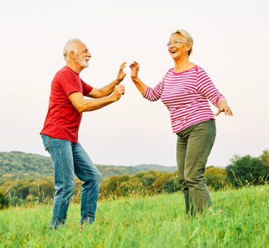 Kadın erkek açık havada mutlu yaşlı çift aktif antrenman yapıyor spor yapıyor birlikte spor yapıyor birlikte emekliliğe ayrılıp dans etmeyi seviyor.
