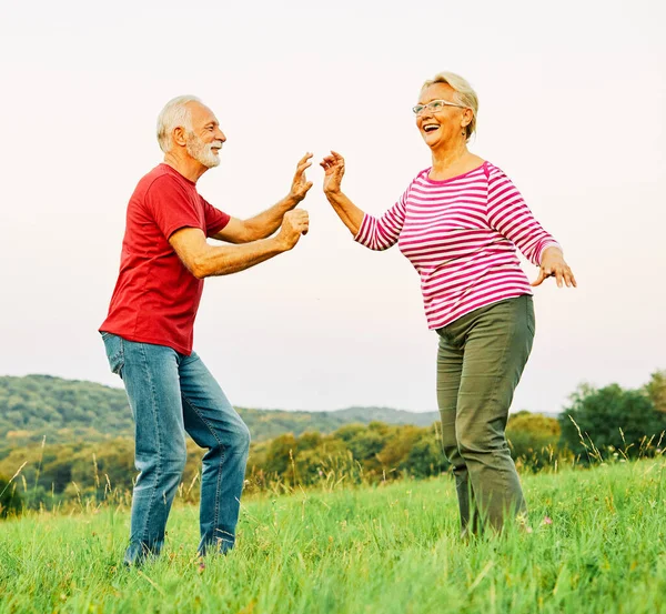 Woman man outdoor senior couple happy elderly training active exercise stretching fitness retirement together love dancing nature mature — Stock Photo, Image