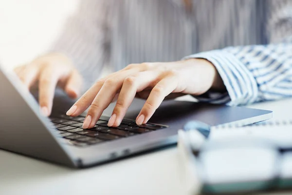 Close up of womans hands typing on aloptop in an office or at home