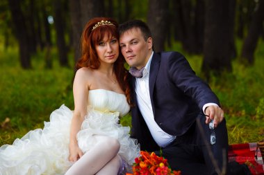 Kızıl saçlı gelin ve damat, yeşil kutusunda gr üzerinde oturan, düğün