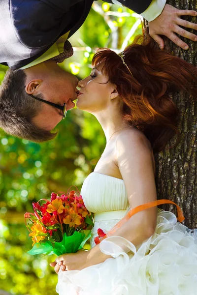 Sposo appeso a testa in giù da un albero in una foresta verde e rosso — Foto Stock