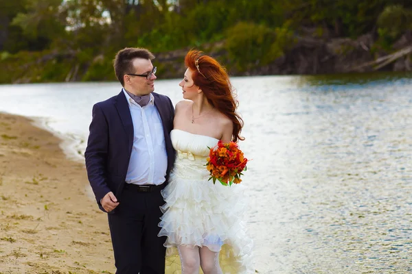 Bride and groom newlyweds go by river — Stock Photo, Image