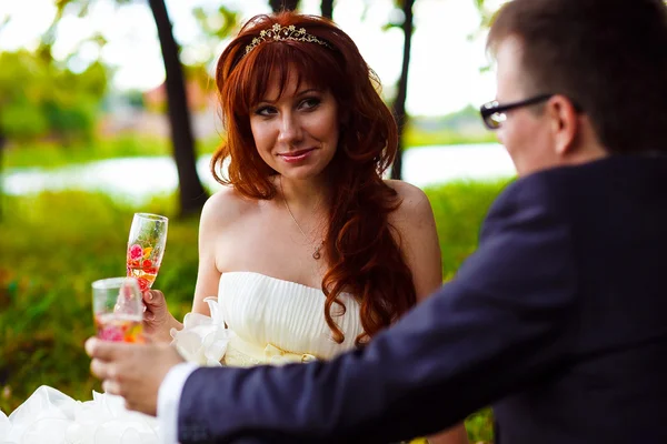 Zrzka nevěsta a ženich, svatba v zelené pole, sedí na picn — Stock fotografie