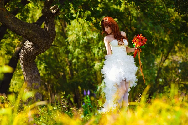 Samotna kobieta w białej sukni na ślub panny młodej jest drzewo w gr — Zdjęcie stockowe