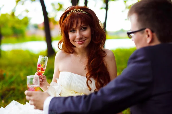 赤毛の花嫁と花婿、ピクニックに座っている緑色のボックスでの結婚式 — ストック写真