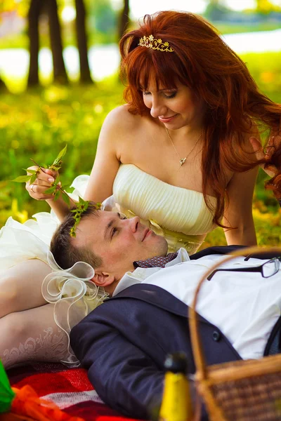 In Russland Paar Braut und Bräutigam kommunizieren sitzend auf grünem Gras — Stockfoto