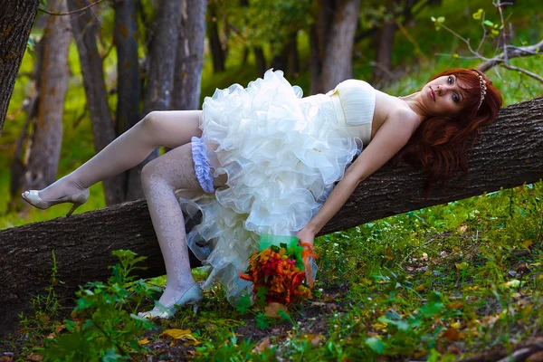 Bride red haired woman in a white dress with sexy legs with gart — Stock Photo, Image