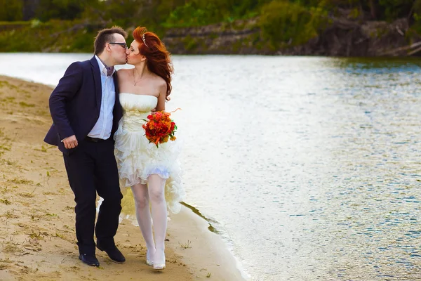 Frisch verheiratete Paare am Strand am Fluss, Braut und Bräutigam sind — Stockfoto