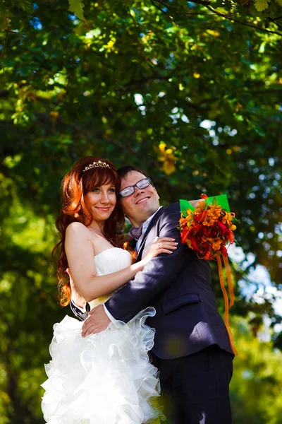 Mariée et marié debout sur fond vert dans la forêt, cheveux roux — Photo