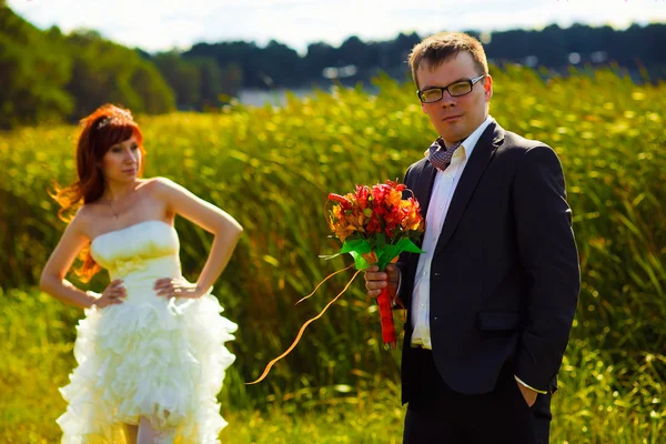 Sposo al matrimonio tenendo bouquet da sposa su uno sfondo di — Foto Stock