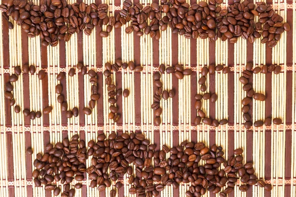 Granos de café en una alfombra con textura palabra — Foto de Stock