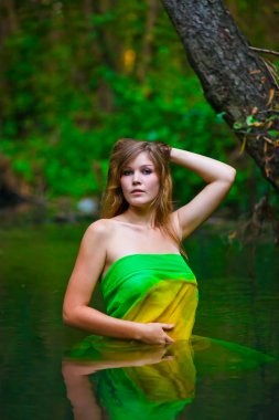 blonde young woman standing waist-deep water in river in a green clipart