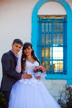 Çift Pencere çubukları ile eski bina, yeni evli çift erkek ve