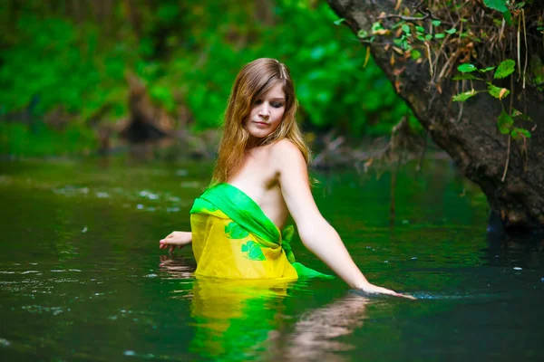 Mujer joven rubia de pie agua de la cintura en el río en verde para —  Fotos de Stock