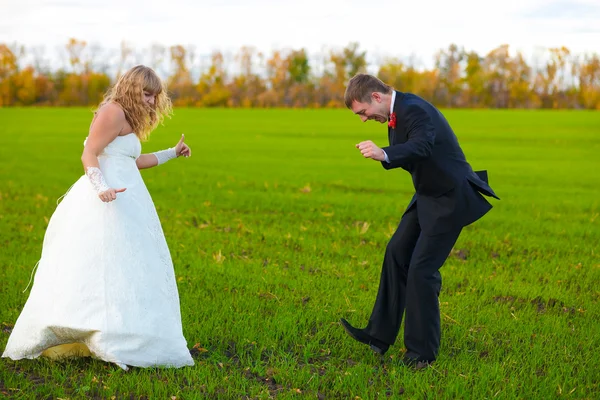 Sposo e sposa che ballano allegramente in campo verde, coppia, matrimonio — Foto Stock