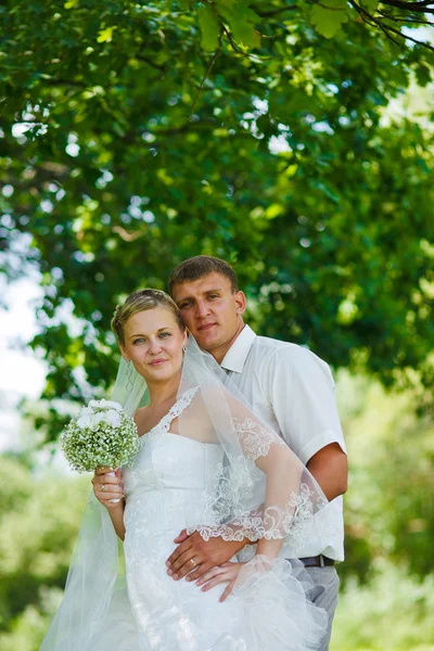 Noivo noiva recém-casados loira em pé em uma floresta verde no summe — Fotografia de Stock