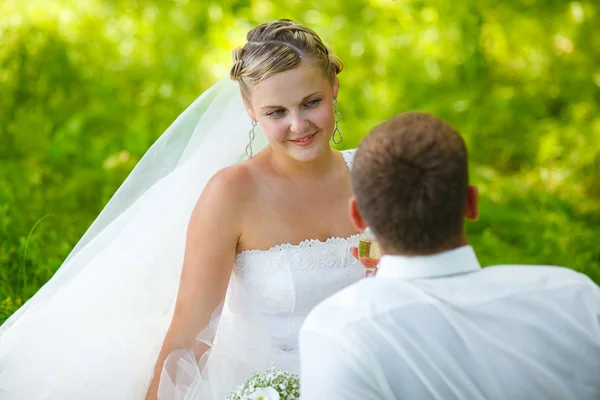 Bride looking at groom wedding couple on a green background — Stock Photo, Image