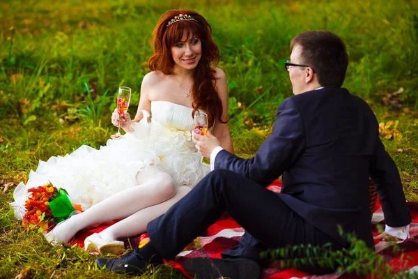 En Rusia pareja novia y novio sentado en la hierba verde, picnic — Foto de Stock