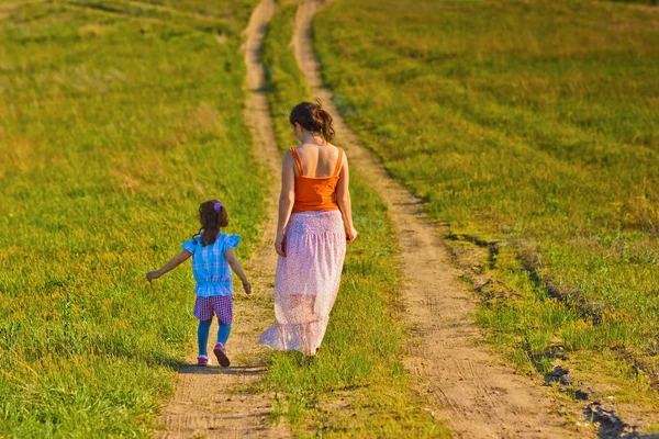 Anne, kadın ve küçük kızı kızım git kırsal yol throu üzerinde