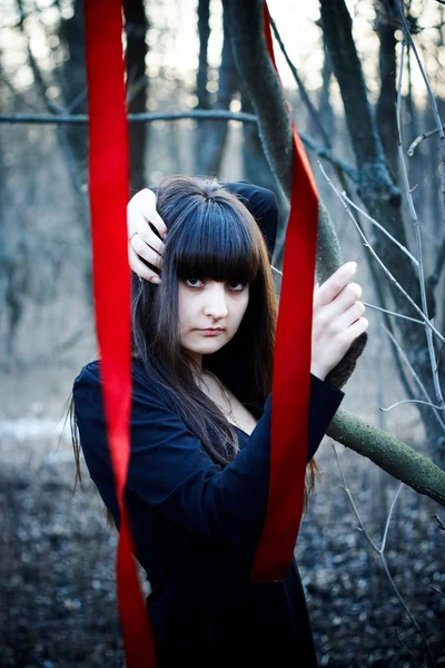 Bruja con cintas rojas en el bosque — Foto de Stock