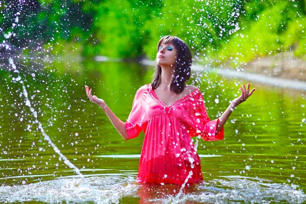 穿红裙子的女人模型齐腰站在雨中 — 图库照片