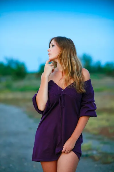 Wanita muda rajutan gaun ungu di latar belakang biru dengan natu — Stok Foto