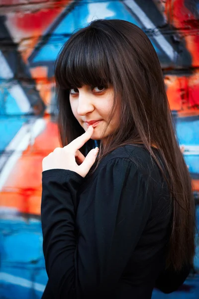 Graffiti wall and a girl holding a finger in the face — Stock Photo, Image