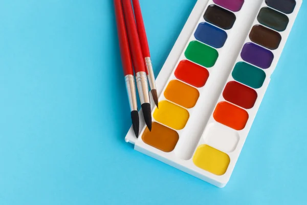 Brushes for watercolors paints for children on blue background — Stock Photo, Image