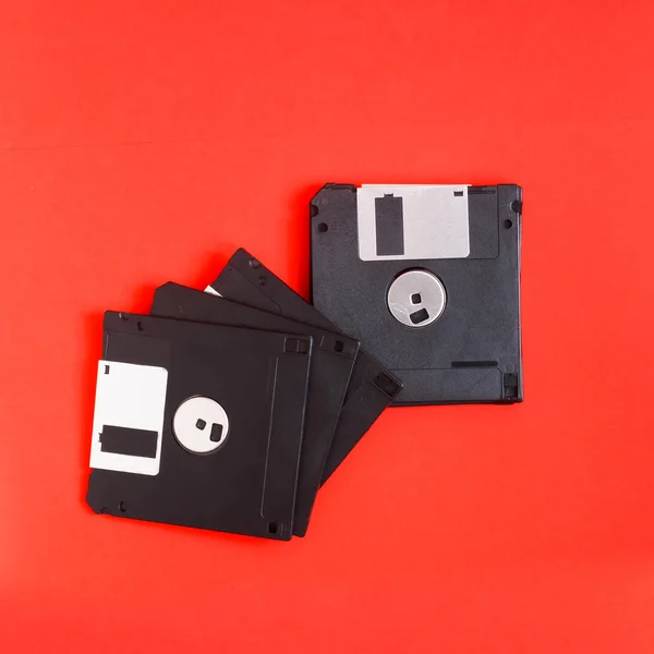 Suporte de armazenamento de dados de computador magnético de disquete em uma parte traseira vermelha — Fotografia de Stock