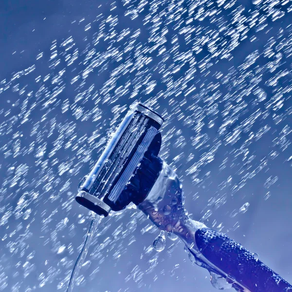 Holicí strojek na holení ve vodě s padající kapky a spreje — Stock fotografie
