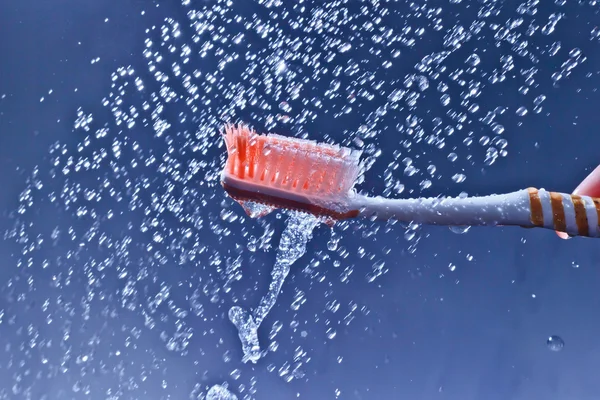 Toothbrush in water to spray and drops — Stock Photo, Image